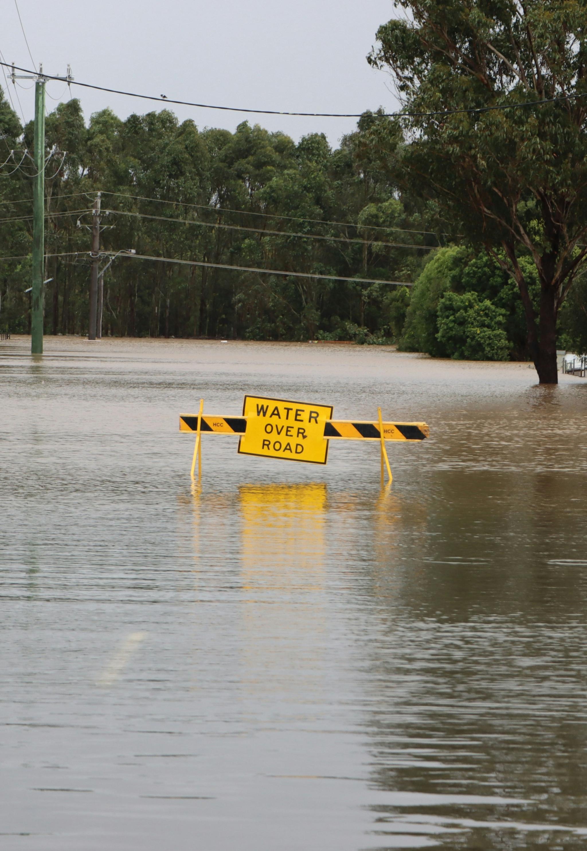 Flooded road with a caution sign