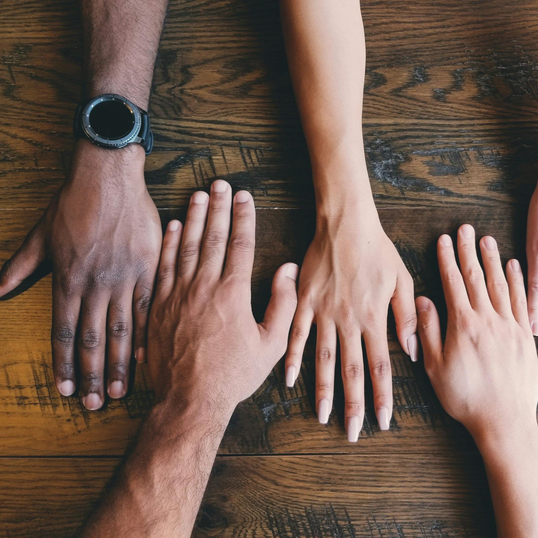 Five hands on a table