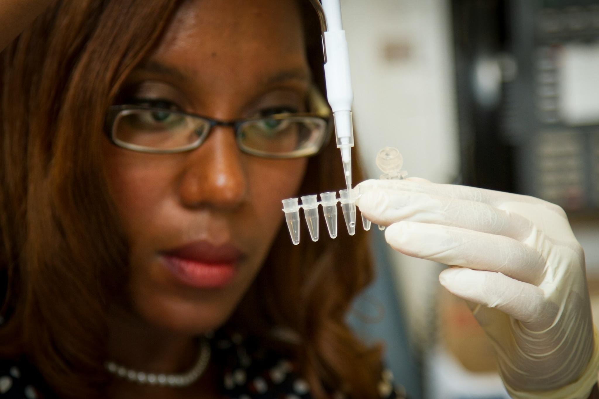 Chanelle Case Borden, Ph.D., a postdoctoral fellow in the National Cancer Institute's Experimental Immunology Branch, pipetting DNA samples into a tube for polymerase chain reaction, or PCR, a laboratory technique used to make multiple copies of a segment of DNA.